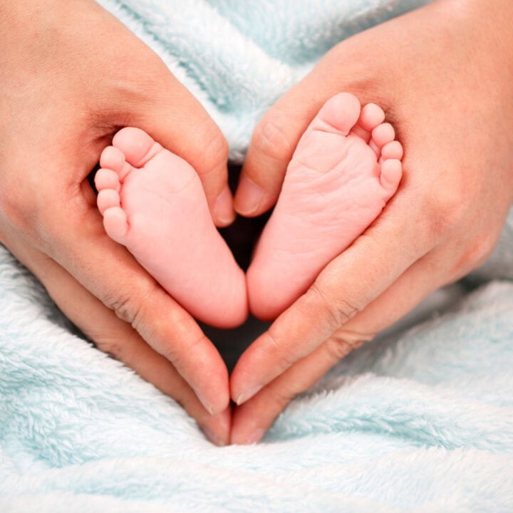 baby feet in mums hands heart