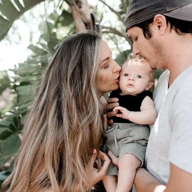 mum dad kissing baby